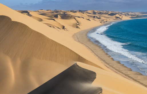Namib desert dunes with ocean in the background