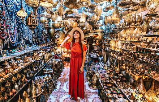 A young traveler exploring a copper souvenir handicraft shop in Marrakesh, Morocco, embodying a travel lifestyle experience.